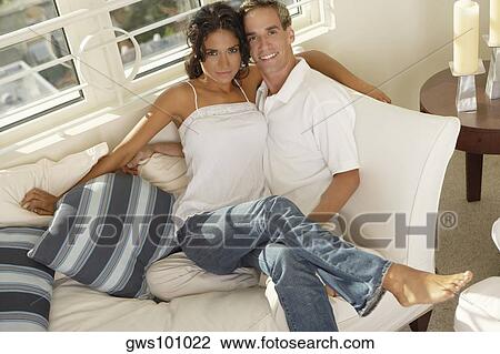 Stock Image - Portrait of a young woman sitting on a young man's lap. Fotosearch