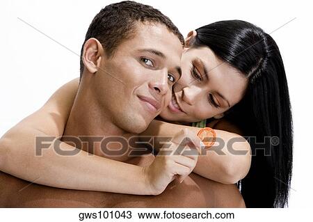 Young woman holding a condom embracing a young man from behind View Large Photo Image Stock Image - Young woman holding a condom embracing a young man from behind. Fotosearch
