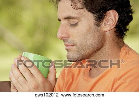 Close-up of a mid adult man holding a cup of tea View Large Photo Image Stock Image - Close-up of a mid adult man holding a cup of tea. Fotosearch