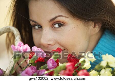 Close-up of a young woman with a bouquet of flowers View Large Photo Image Stock Image - Close-up of a young woman with a bouquet of flowers. Fotosearch