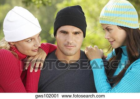 Close-up of two young women with a mid adult man View Large Photo Image Stock Image - Close-up of two young women with a mid adult man. Fotosearch