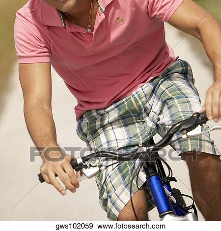 Mid section view of a young man riding a bicycle View Large Photo Image Stock Photo - Mid section view of a young man riding a bicycle. Fotosearch