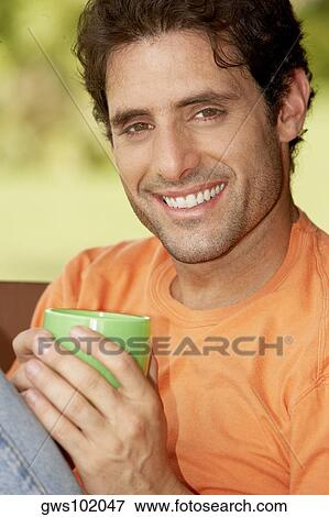 Portrait of a mid adult man holding a cup of tea View Large Photo Image Stock Photo - Portrait of a mid adult man holding a cup of tea. Fotosearch