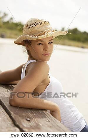 Portrait of a young woman leaning against a pier View Large Photo Image Stock Image - Portrait of a young woman leaning against a pier. Fotosearch