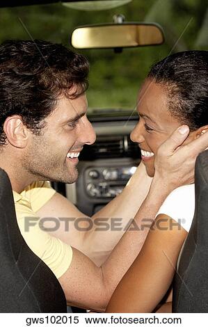 Stock Photography - Side profile of a young woman embracing a mid adult man. Fotosearch