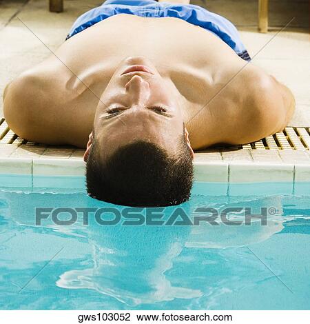 Close-up of a young man lying at the poolside View Large Photo Image Stock Image - Close-up of a young man lying at the poolside. Fotosearch