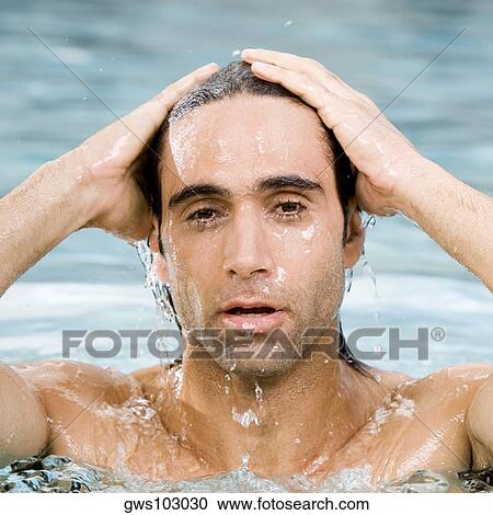 Stock Image - Portrait of a mid adult man swimming in a swimming pool. Fotosearch