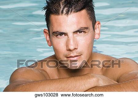 Stock Photo - Portrait of a young man in a swimming pool. Fotosearch