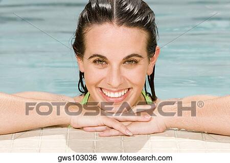 Portrait of a young woman leaning at the edge of a swimming pool View Large Photo Image Stock Photograph - Portrait of a young woman leaning at the edge of a swimming pool. Fotosearch