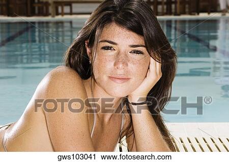 Portrait of a young woman lying at the poolside View Large Photo Image Stock Image - Portrait of a young woman lying at the poolside. Fotosearch