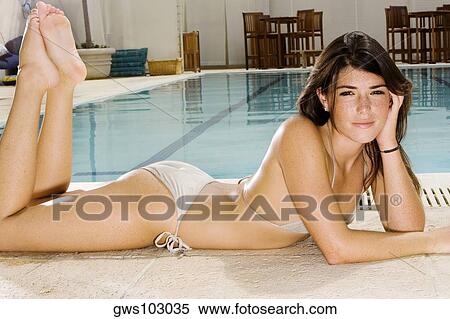 Portrait of a young woman lying at the poolside View Large Photo Image Stock Photography - Portrait of a young woman lying at the poolside. Fotosearch