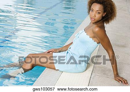 Portrait of a young woman sitting at the poolside View Large Photo Image Stock Photo - Portrait of a young woman sitting at the poolside. Fotosearch