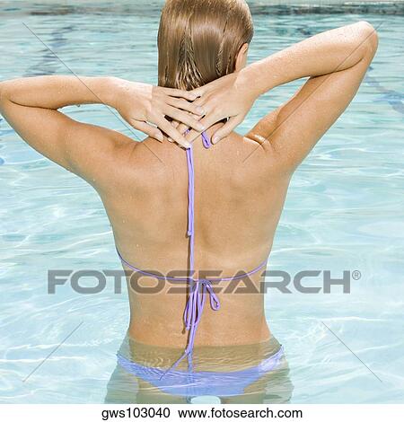 Rear view of a young woman in a swimming pool View Large Photo Image Stock Image - Rear view of a young woman in a swimming pool. Fotosearch