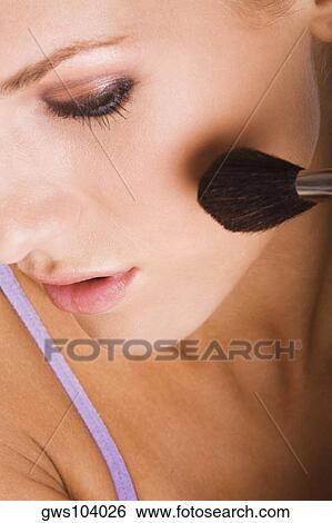 Close-up of a young woman applying blush with a brush View Large Photo Image Stock Photograph - Close-up of a young woman applying blush with a brush. Fotosearch