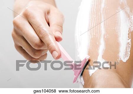 Low section view of a woman shaving her leg with a razor View Large Photo Image Stock Photo - Low section view of a woman shaving her leg with a razor. Fotosearch