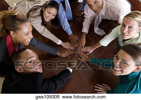 Stock Photo - High angle view of a group of business executives with their hands on a table. Fotosearch