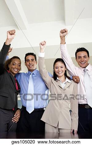 Portrait of two businessmen and two businesswomen standing with their hands raised View Large Photo Image Stock Image - Portrait of two businessmen and two businesswomen standing with their hands raised. Fotosearch