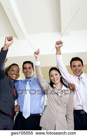 Portrait of two businessmen and two businesswomen standing with their hands raised View Large Photo Image Stock Photography - Portrait of two businessmen and two businesswomen standing with their hands raised. Fotosearch