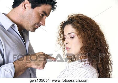 Side profile of a mid adult man pointing to a young woman View Large Photo Image Picture - Side profile of a mid adult man pointing to a young woman. Fotosearch