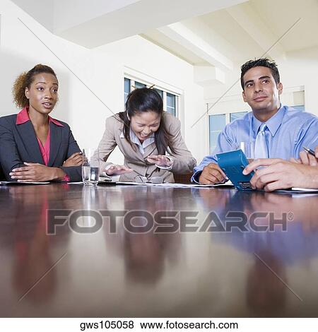 Two businesswomen and a businessman in an office View Large Photo Image Stock Photo - Two businesswomen and a businessman in an office. Fotosearch