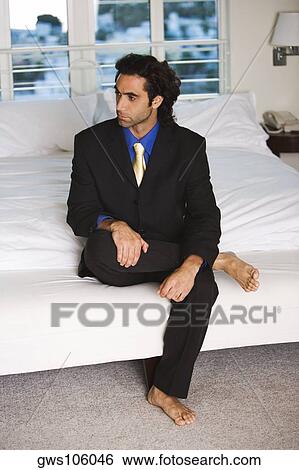 Businessman sitting on the bed View Large Photo Image Stock Photograph - Businessman sitting on the bed. Fotosearch