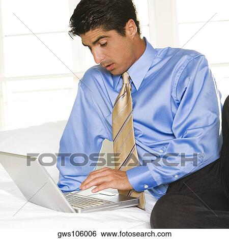 Businessman working on a laptop View Large Photo Image Stock Photograph - Businessman working on a laptop. Fotosearch