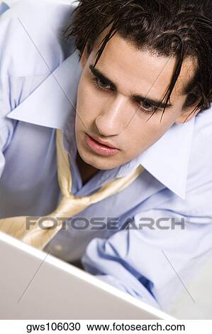 Close-up of a businessman looking at a laptop View Large Photo Image Stock Image - Close-up of a businessman looking at a laptop. Fotosearch