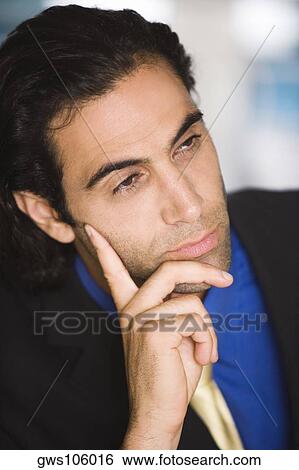 Stock Photograph - Close-up of a businessman with his hand on his cheek. Fotosearch