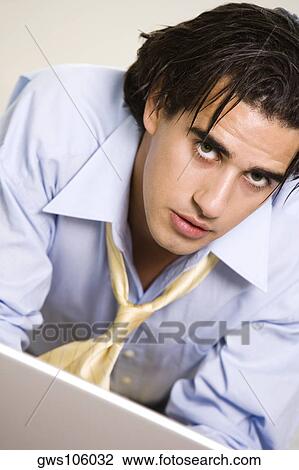 Portrait of a businessman in front of a laptop View Large Photo Image Stock Image - Portrait of a businessman in front of a laptop. Fotosearch