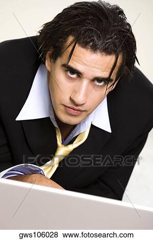 Portrait of a businessman in front of a laptop View Large Photo Image Stock Photo - Portrait of a businessman in front of a laptop. Fotosearch