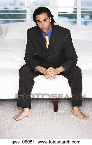Portrait of a businessman sitting on a bed View Large Photo Image Stock Image - Portrait of a businessman sitting on a bed. Fotosearch