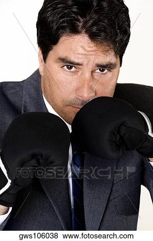 Stock Photo - Portrait of a businessman wearing boxing gloves. Fotosearch