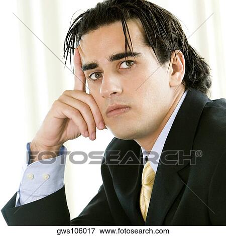 Stock Photo - Portrait of a businessman with his finger on his head. Fotosearch