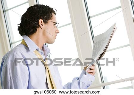 Side profile of a businessman reading a newspaper View Large Photo Image Stock Image - Side profile of a businessman reading a newspaper. Fotosearch