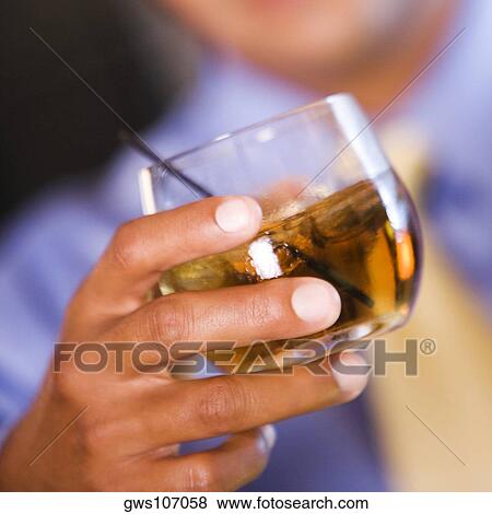 Businessman holding a glass of wine View Large Photo Image Stock Photo - Businessman holding a glass of wine. Fotosearch