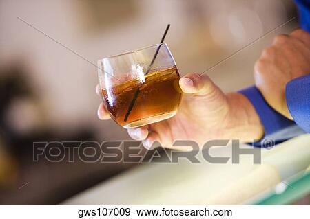 Close-up of a man's hand holding a glass of wine View Large Photo Image Stock Photo - Close-up of a man's hand holding a glass of wine. Fotosearch