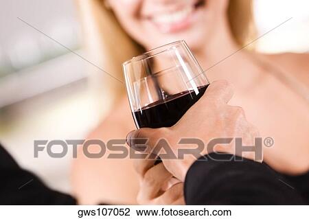 Close-up of a young couple holding glasses of wine View Large Photo Image Stock Image - Close-up of a young couple holding glasses of wine. Fotosearch