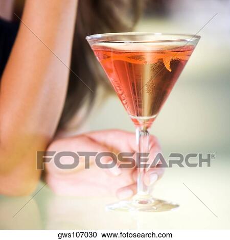 Close-up of a young woman's hand holding a glass of martini View Large Photo Image Stock Image - Close-up of a young woman's hand holding a glass of martini. Fotosearch