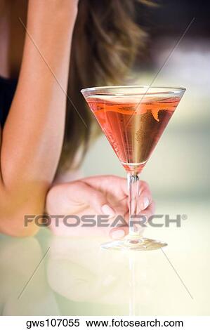 Close-up of a young woman's hand holding a glass of martini View Large Photo Image Stock Photography - Close-up of a young woman's hand holding a glass of martini. Fotosearch