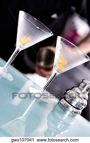 Stock Image - Close-up of two martini glasses and a cocktail shaker on a bar counter. Fotosearch