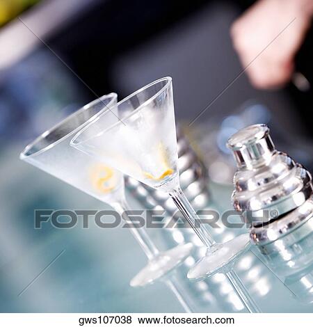 Close-up of two martini glasses and a cocktail shaker on a bar counter View Large Photo Image Stock Photo - Close-up of two martini glasses and a cocktail shaker on a bar counter. Fotosearch
