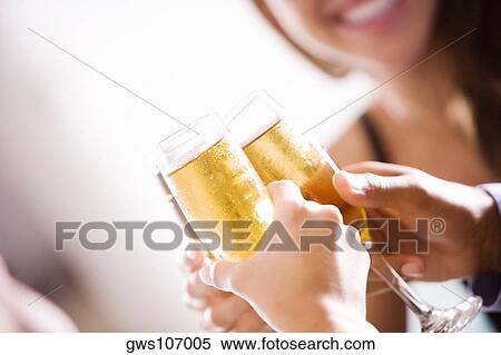 Close-up of two men and a woman toasting champagne flutes View Large Photo Image Stock Photography - Close-up of two men and a woman toasting champagne flutes. Fotosearch