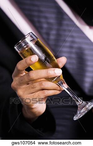 Mid section view of a businessman holding a champagne flute View Large Photo Image Picture - Mid section view of a businessman holding a champagne flute. Fotosearch