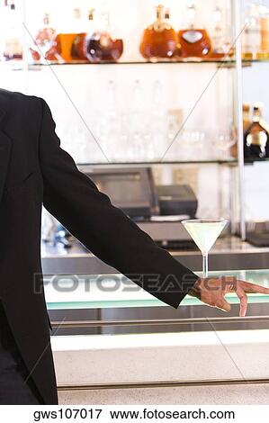 Mid section view of a businessman standing at a bar counter View Large Photo Image Stock Photo - Mid section view of a businessman standing at a bar counter. Fotosearch