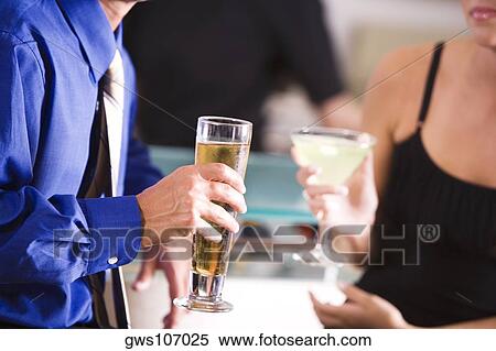 Mid section view of a man and a woman in a bar View Large Photo Image Stock Photography - Mid section view of a man and a woman in a bar. Fotosearch