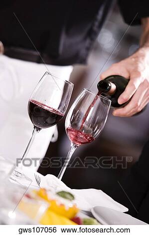 Mid section view of a man pouring red wine into a wineglass View Large Photo Image Stock Photograph - Mid section view of a man pouring red wine into a wineglass. Fotosearch