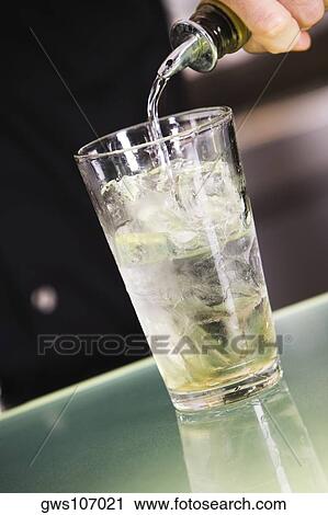 Mid section view of a man pouring alcohol into a glass filled with ice View Large Photo Image Stock Image - Mid section view of a man pouring alcohol into a glass filled with ice. Fotosearch