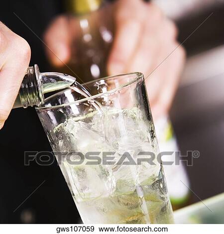 Mid section view of a man pouring alcohol into a glass filled with ice View Large Photo Image Stock Photo - Mid section view of a man pouring alcohol into a glass filled with ice. Fotosearch