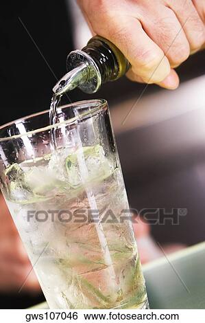 Mid section view of a man pouring alcohol into a glass filled with ice View Large Photo Image Stock Photograph - Mid section view of a man pouring alcohol into a glass filled with ice. Fotosearch