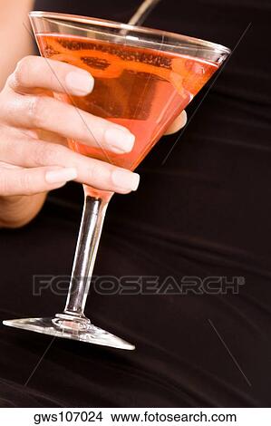 Mid section view of a young woman holding a martini glass View Large Photo Image Picture - Mid section view of a young woman holding a martini glass. Fotosearch